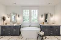 Primary bathroom has a deep soaker tub, double vanities and multiple-head marble shower.