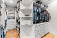 The primary closet is complete with plentiful hanging room, drawers, and shelves