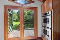 Double doors off the kitchen lead to the back deck and beautiful outdoors