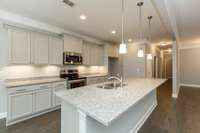 Magnolia kitchen shown with white cabinets (upgrade) and granite countertops. Photos of a previously built home.