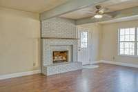 SPACIOUS LIVING ROOM WITH BRAND NEW WOOD FLOORING, GAS LOG FIREPLACE AND BEAMED CEILING