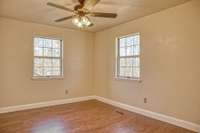 GUEST BEDROOM WITH NEW WOOD FLOORING AND CEILING FAN