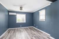 The primary bedroom, custom painted in calming blue, also features a walk in closet and new flooring.