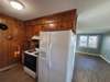 Right side of kitchen has stove and side-by-side fridge