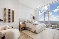 The guest bedroom features beautiful linens, furnishings, and sunrise views.