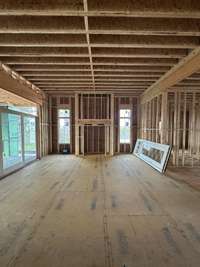 Oversized Great Room with Gas Fireplace - stone / pure white arcusstone, 10' Stained Beams, Slider doors open onto Covered Living Area   *this house is under construction  Built by: Legend Homes Photo taken 3/21/24