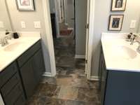 Stock photo of owner's suite with split vanities and access to laundry room