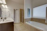 Double vanities and a separate shower and tub complement the primary suite