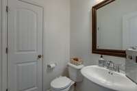 This half bath is located adjacent to the main floor guest bedroom