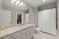 Bedroom #2 ensuite bathroom. Closet can be seen in the mirror reflection. Shower tub combo.