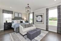 Oversized primary suite downstairs boasting with natural light! King size furnishings shown here.