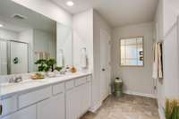 Primary Bath with double sink and large glassed shower.