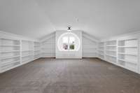 GORGEOUS bonus room with surround built-ins and the most dreamy circular window with a sitting nook