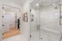 Primary bath leads to the spacious walk in closet with custom built ins.
