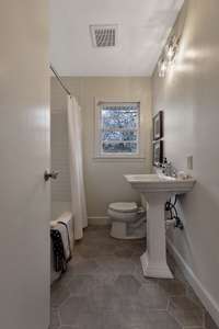 Newly updated full bathroom with tub/shower combo and pedestal sink