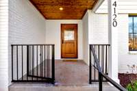 Front door with iron gate that can closed handrails that extend all the way to the driveway.