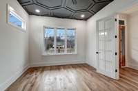 Beautiful office with accent ceiling overlooking from porch/yard.