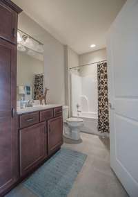 Full bath w/storage tower cabinet. Shower bath combo, tile floors.