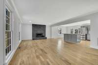 Primary living room with open concept layout and wood burning fireplace.