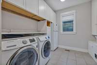 Large laundry room with built in drying racks, cabinets, washer, dryer and full size additional refrigerator. All appliances convey with the home.