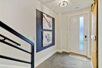 Interior view of front door with privacy glass. Nice millwork, high ceilings, designer lighting