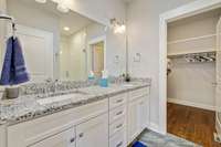 Primary bath w/ the walk-in closet and a double vanity. Hardwood, Granite and Tile.