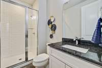 Ensuite full bath, dark granite surfaces.Tile and glass.