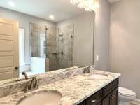 Primary Bath w. Custom Raised Double Vanities and Tile Walk-In Shower w/ Frameless Shower Door.