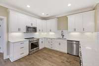 Stainless steel appliances and recessed lighting in the kitchen as well as under cabinet lighting
