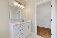 Spare bathroom with beautiful cabinets, lighting and tile flooring