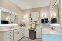 Primary bathroom with lots of lighting, gorgeous tile flooring, and beautiful hard surface countertops.