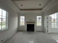 Study off the Foyer features a grand fireplace.  *This home is under construction. Photo updated 4/9/24