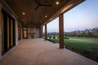 Covered outdoor living space with fireplace and outdoor kitchen.  *this home is virtually staged. Built by: Schumacher Homes, LLC