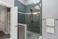 The primary bathroom has a large walk-in shower and with modern tile.