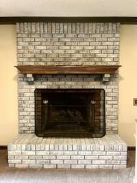 The den boasts a distinctive brick hearth gas fireplace complemented by a classic wood mantle, a feature that is increasingly rare to find in homes today. Can be easily b converted to a woodburning fireplace.