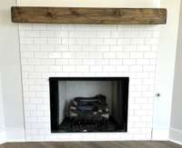 Gas fireplace with subway styled tile surround and floating mantle.