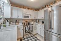 Remodeled kitchen with granite, ample cabinets, microwave, stove.