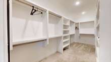 Primary closet provides custom built in shelves for excellent organized storage.