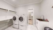 Laundry/utility room is conveniently adjacent to primary closet and includes a SS utility sink