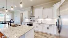 The kitchen boasts stunning granite countertops with white picket ceramic tile backsplash!
