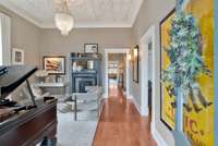 Living Room to impress w 11’ ceilings w tin accents original Fireplace is decorative gleaming vintage floors