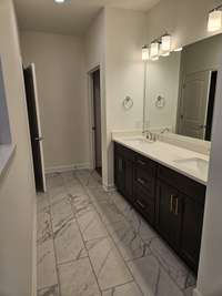 There are double sinks with quartz counter tops and 12x24 tiles in the primary bathroom. It also has a separate water closet and a large walk in closet.