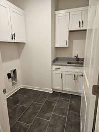 A laundry room to die for! In includes tons of storage cabinets and a convenient sink.