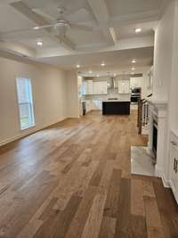 Generous open floor plan. The living area features a coffered ceiling and there is crown mold throughout the first floor. Also notice the hardwood floors throughout the main floor as well.