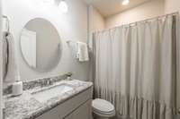 There is a main level bath and bedroom. Granite tops and white cabinets are a nice add to this bathroom.