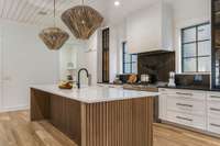 Expansive kitchen island and glass-fronted cabinets.  6-burner Jenn-Aire stove