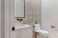 Unique design features such as this playful tile on the half bath that services the rec/media room