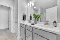 Primary ensuite bath with dual vanities, large walk-in closet & linen closet. (This home is similar to the home under construction. Selections may vary, please see listing media for details).