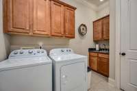 Main floor laundry with sink & storage galore