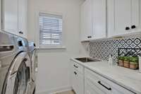 The owners took the original, boring laundry room and turned it into WOW! The owners recently updated this room with new cabinets, new hardware, new laundry sink, new faucet, new countertops and striking accent wallpaper --a total transformation!